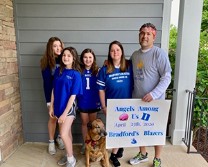 family with dog and a sign that says "Angels Among Us"