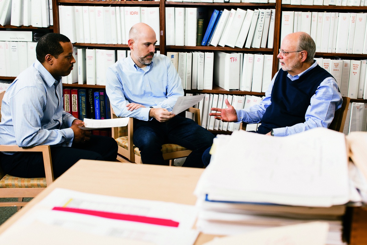 three men in a meeting