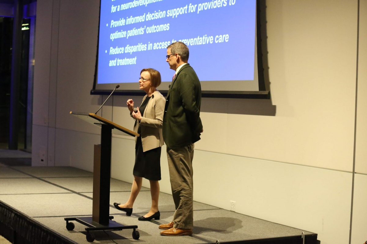 man and woman on stage giving a presentation