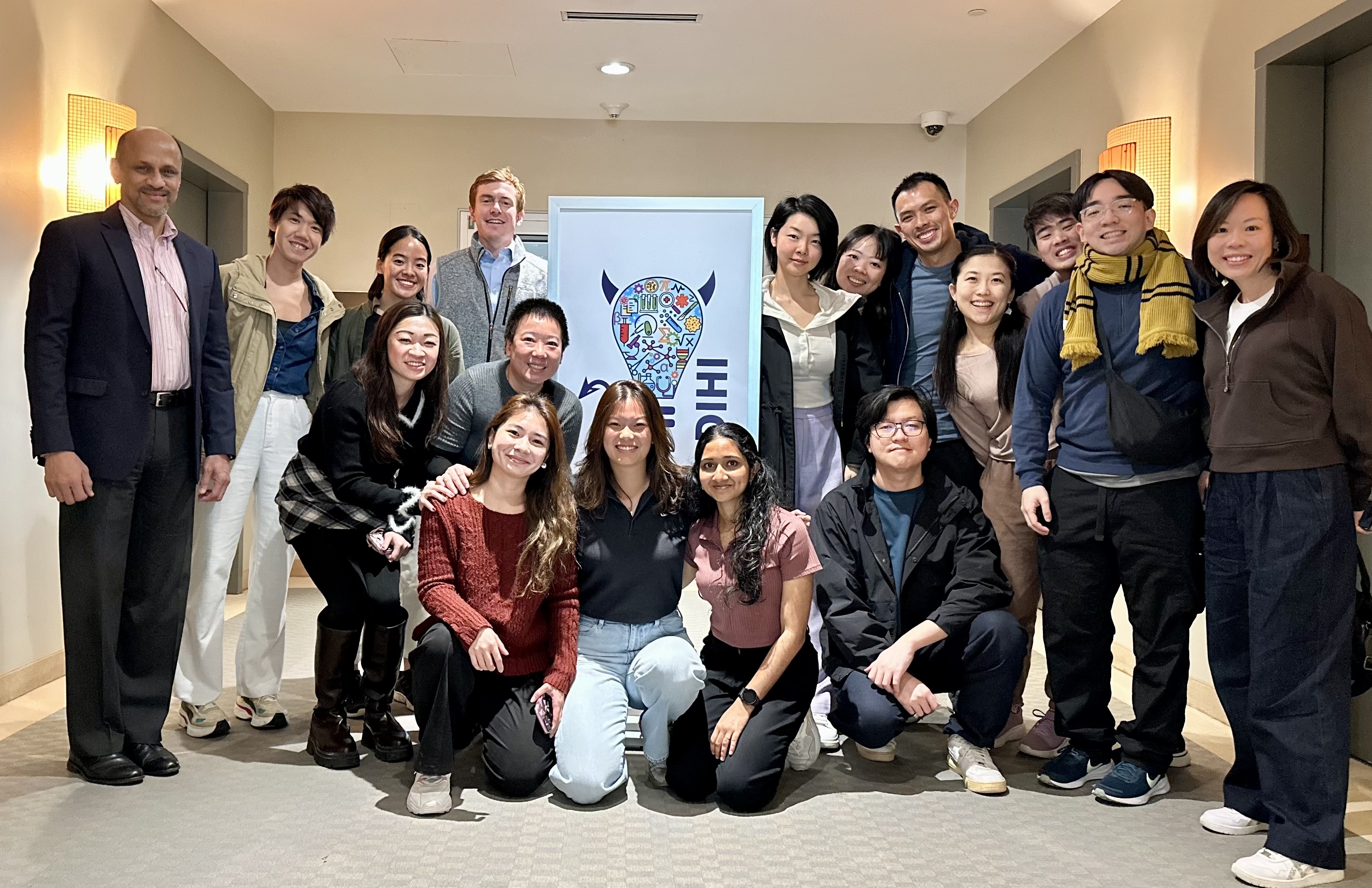 D-HIP students and DIHI staff group photo in front of the DIHI office sign.