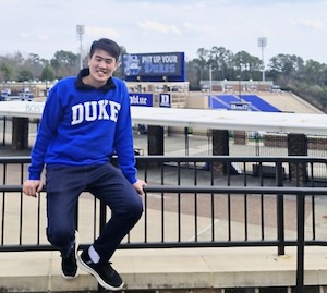 Photo: Duke-NUS student Jasper Chua sitting in front of Duke's football stadium