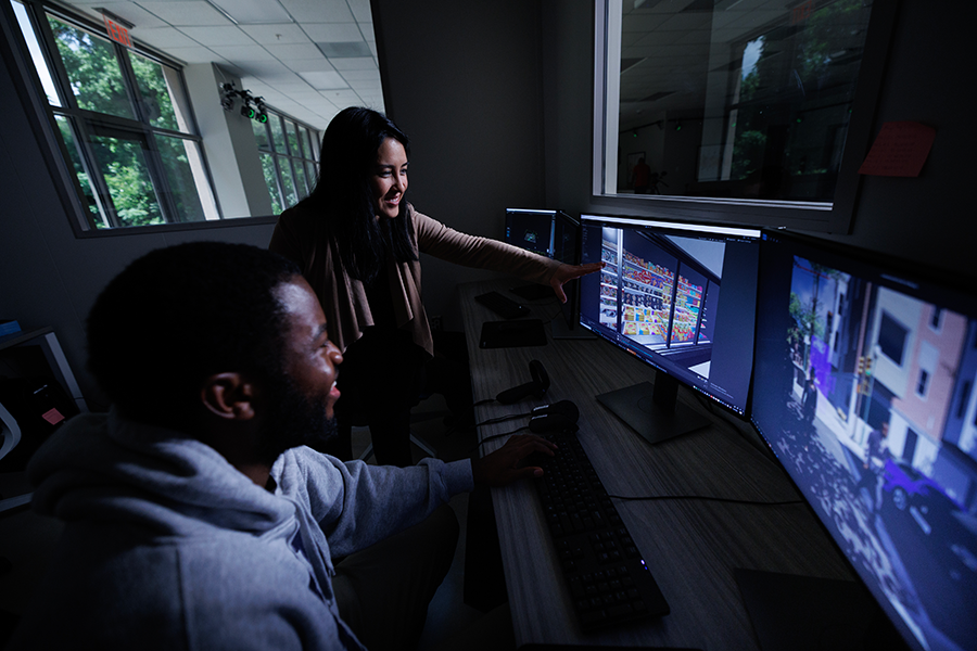 Suthana in the lab with a colleague reviewing data on computers.
