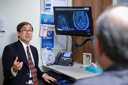 Eugene Vaios, MD, MBA, reviews a brain scan of tumors treated with stereotactic radiosurgery, high-dose, precision radiation. 