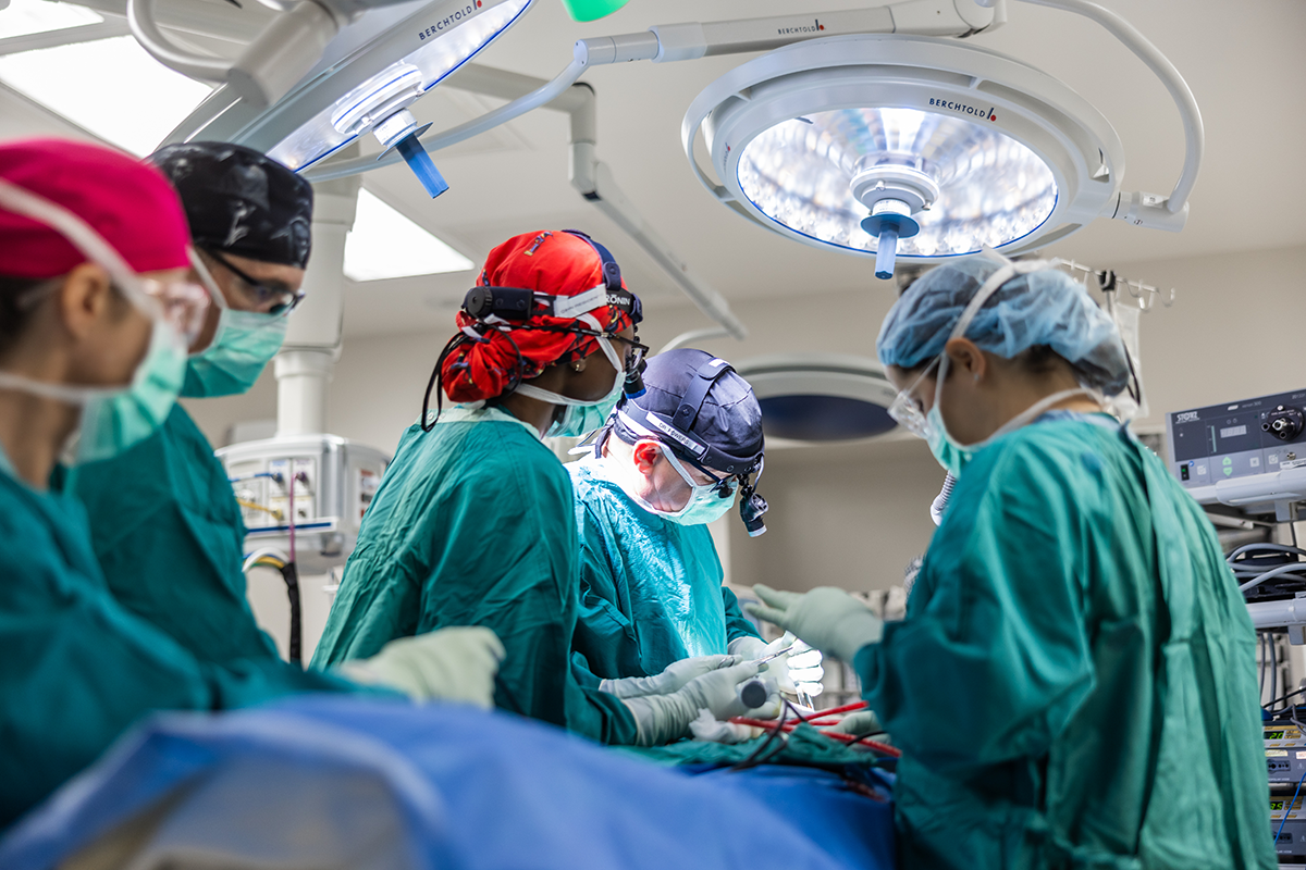 Dr. Powers performing a surgery, surrounded by his surgical team. 