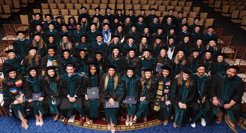 A full class of students in robes sitting in an auditorium
